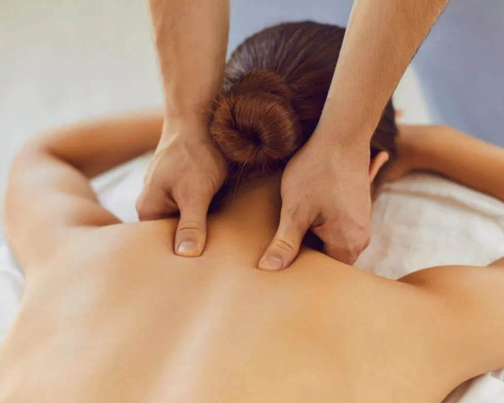 Registered massage therapist working on a patient on a clinic table